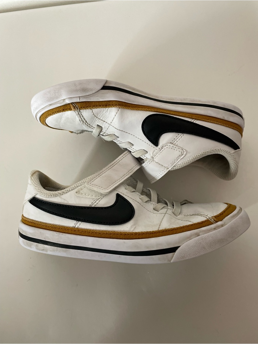 Nike Men’s White Sneakers with Black Swoosh and Gold Accent